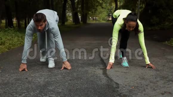 健身夫妇准备在户外公园的木制人行道上跑步视频的预览图