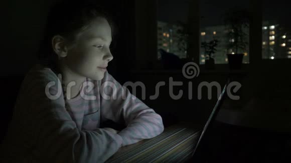 晚上躺在床上看着平板电脑的小女孩视频的预览图