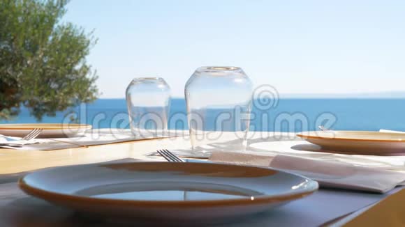 可俯瞰大海的室外咖啡馆提供服务的桌子视频的预览图