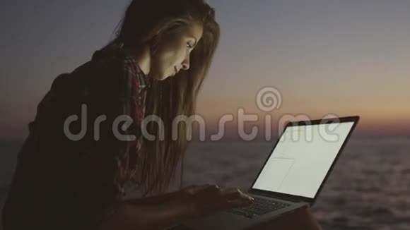 在海滩上用笔记本电脑的女孩视频的预览图
