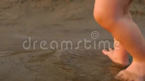 孩子们的腿在沙滩上玩水特写慢动作视频的预览图