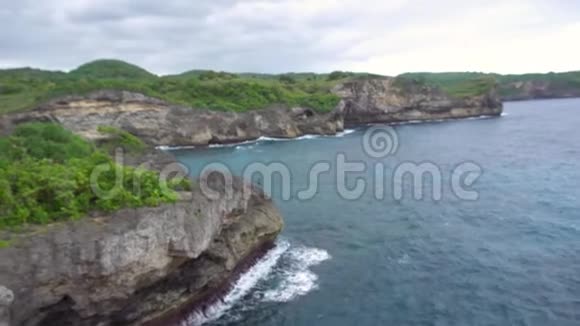 在美丽的风景背景下高高的悬崖海浪上展示拇指的人视频的预览图