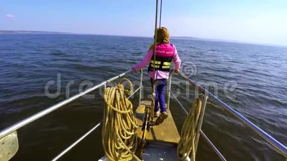 年轻女孩站在游艇的船头双臂张开望着前方视频的预览图