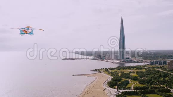 一只风筝在河岸边飞旁边是一座美丽的高楼自由和成功的概念视频的预览图