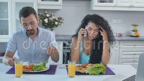 3男人吃早餐时因妻子打电话而感到烦恼视频的预览图