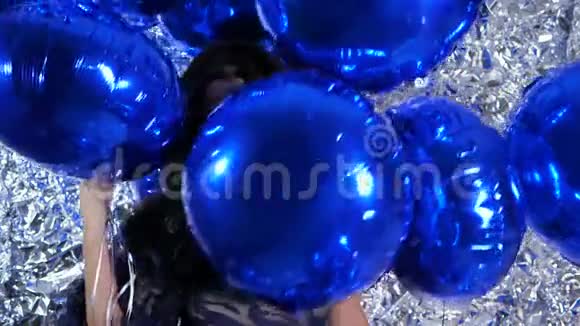 蓝气球在背景闪闪发光的墙上美丽的女士手中视频的预览图