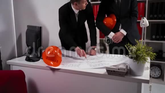 商务办公室的两个工程师商人用头盔看建筑师视频的预览图