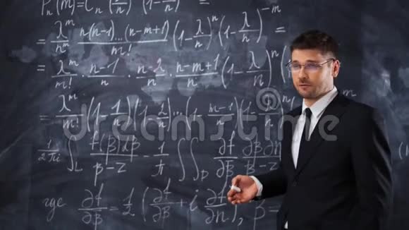 年轻聪明的男性教师或学生解释硬数学方程式的决定视频的预览图