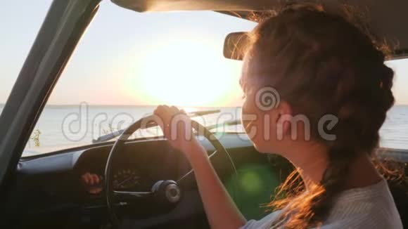 夏日乘小轿车赴江旅途愉快海边小车前座年轻女子视频的预览图