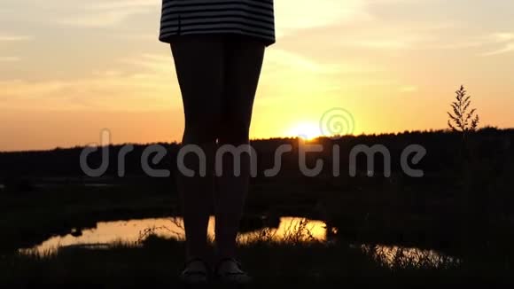 夕阳西下年轻的孕妇站在湖岸上视频的预览图