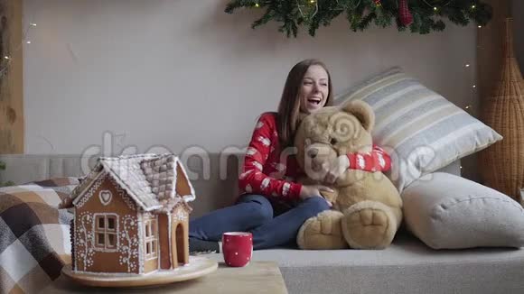 坐在沙发上抱着玩具熊的年轻女子视频的预览图