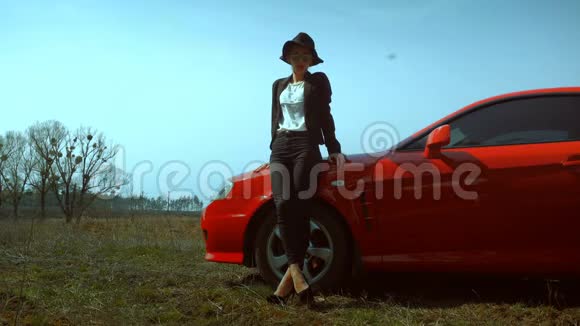 穿高跟鞋的女士站着红色跑车视频的预览图