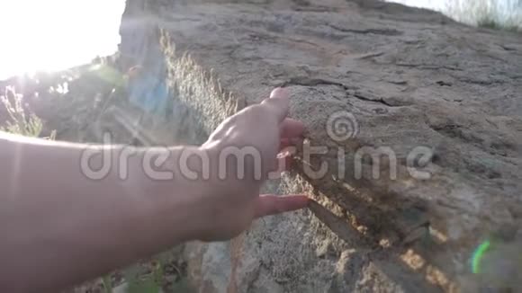 考古学概念人触摸手石花岗岩岩石阳光大自然野生古岩石的生活方式视频的预览图