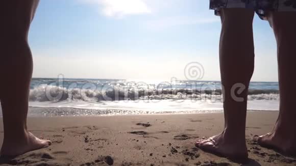 年轻的男人和女人站在岸上在日出时享受大海宁静的海浪在沙滩上翻滚视频的预览图