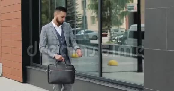 一个年轻英俊的商人学生穿着西装带着一个公文包在车站在机场或商务场合视频的预览图