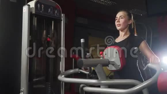 健身房里的女孩体重训练在背部的肌肉上工作在健身房锻炼划船的女人妇女视频的预览图
