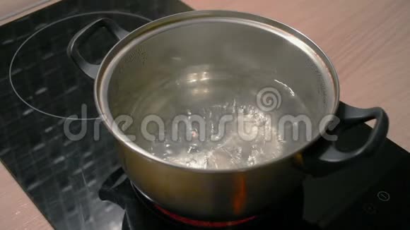 在黑色电磁炉上用金属平底锅煮水视频的预览图