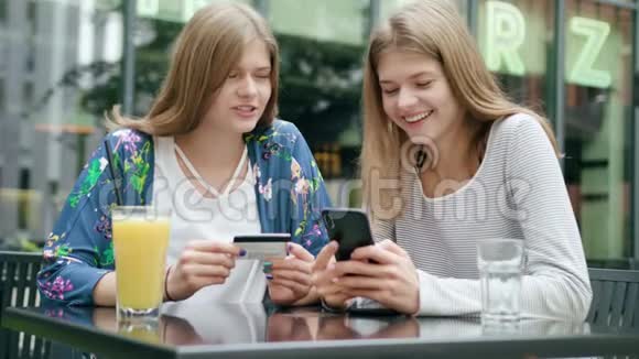 年轻女士用电话拿信用卡视频的预览图