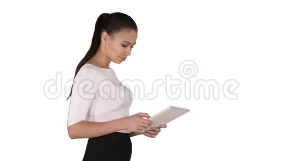 漂亮的女商人在白色背景下行走时使用数字平板电脑视频的预览图