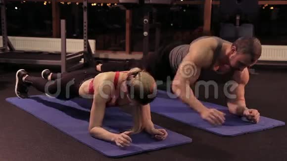健身女孩和肌肉男一起在健身房锻炼视频的预览图