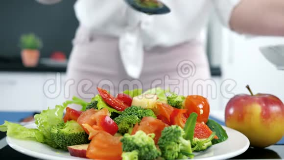 厨房里新鲜的有机沙拉橄榄油缓慢地倒在蔬菜上视频的预览图