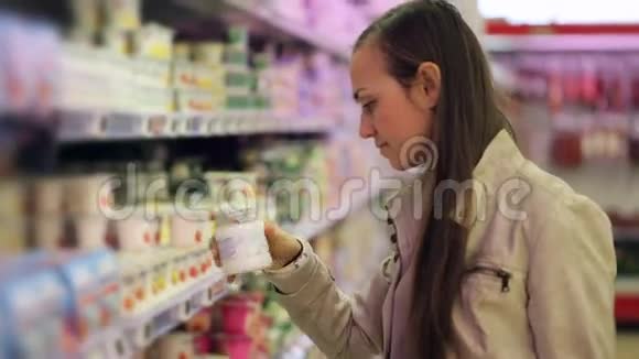 超市里的年轻女性选择奶制品酸奶视频的预览图