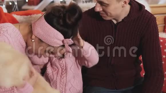 与女儿和狗在圣诞节装饰时幸福的年轻家庭家庭概念视频的预览图
