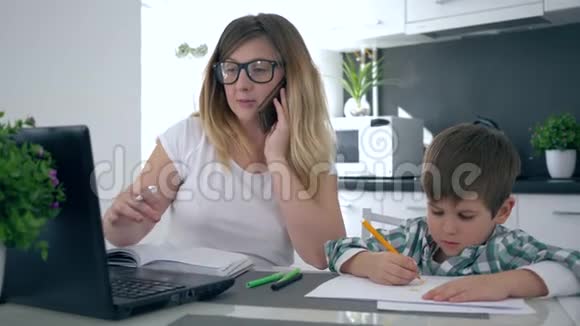 母亲多任务妈妈打电话和孩子一起在家工作视频的预览图