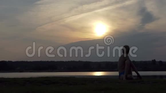 年轻的瑜伽士坐在一只鹰的阿萨纳在斯洛文尼亚的湖岸视频的预览图
