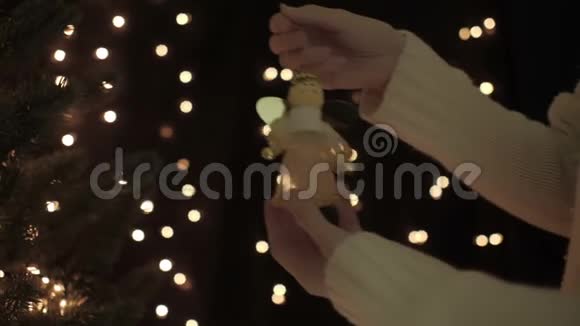 女性在圣诞树上悬挂仙女装饰背景是boke灯光视频的预览图