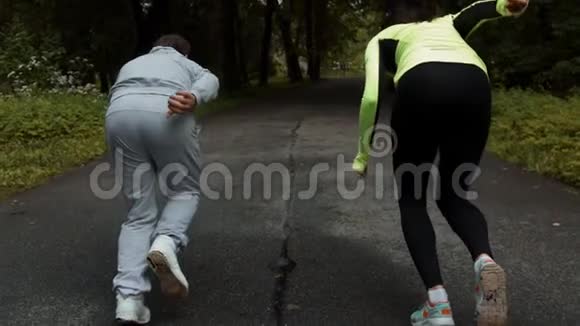 健身情侣准备在户外公园起跑线上的木制人行道上跑步视频的预览图
