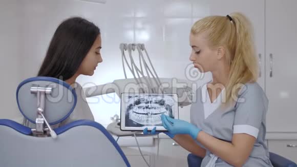 牙医和病人在与医疗设备协商后选择治疗视频的预览图