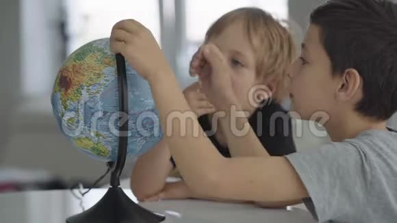 两个高加索男孩旋转地球梦想旅行视频的预览图