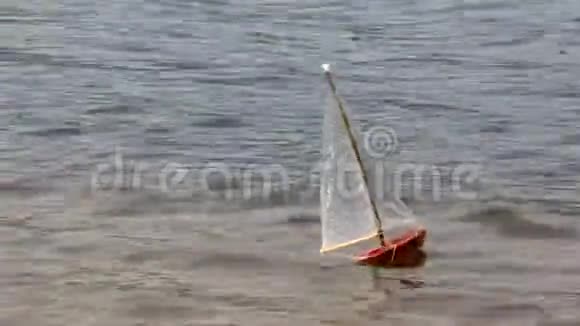 在河上手工制作的玩具帆船视频的预览图