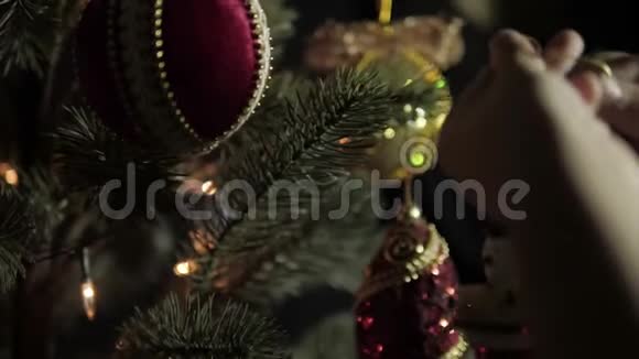 小孩在圣诞树上挂雪人花环视频的预览图