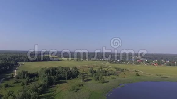 有村庄岛屿海岸线和茂盛植被的大型湖泊的空中全景视频的预览图