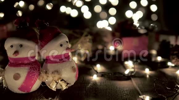在圣诞节期间木制书桌上装饰着圣诞雪人上面还挂着彩灯视频的预览图