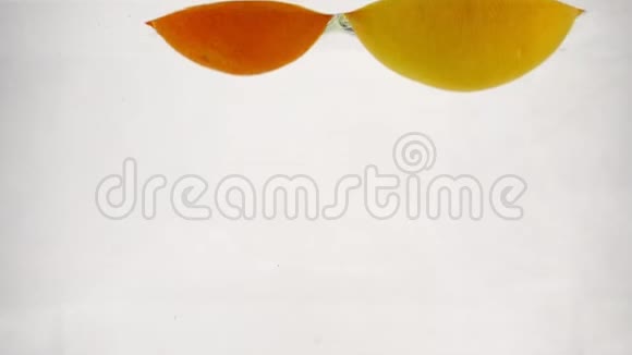一整个葡萄柚和橘子掉进水里有气泡柑橘类水果慢动作视频视频的预览图