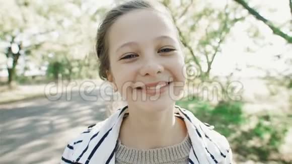 一个年轻微笑的女孩的特写肖像一个甜美的女孩看着相机笑视频的预览图
