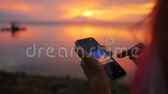 在渔人码头年轻少女在手机上拍摄美丽日落的照片高清慢速运动泰国视频的预览图
