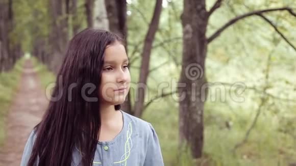 肖像一个甜美美丽的小女孩正在夏天阳光明媚的日子里嗅着一束鲜花站在大自然上视频的预览图