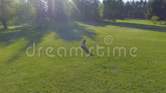 空中观景在阳光明媚的日子里小女孩躺在草地上休息上面的观点草地上的女人视频的预览图