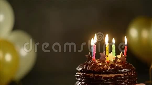 在庆祝活动中用巧克力蛋糕观看令人惊叹的布鲁内特生日女孩许愿吹出五颜六色视频的预览图