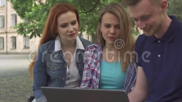 年轻人在校园里看笔记本电脑视频的预览图