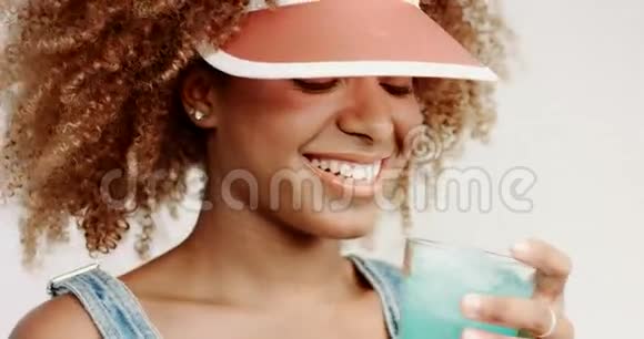 微笑的黑人女人喝蓝色的鸡尾酒视频的预览图
