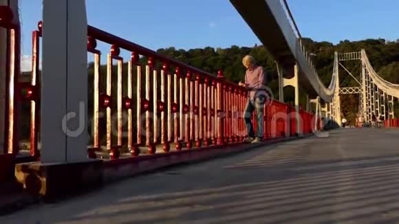 有创意的人站起来在日落时把他的想法放在河桥上视频的预览图