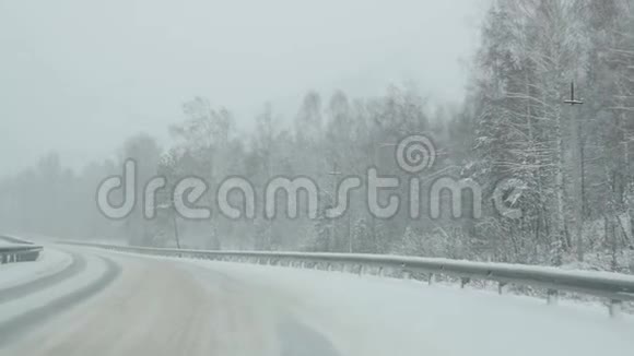 汽车在暴风雪中穿过森林透过挡风玻璃观看慢动作视频的预览图