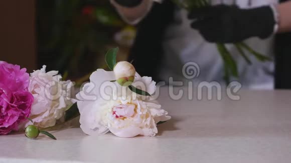 工作中的花商女人做一束白色玫瑰和不同的花花商鲜花店准备花束视频的预览图