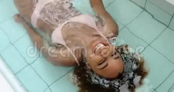 女人躺在游泳池里的水中笑视频的预览图