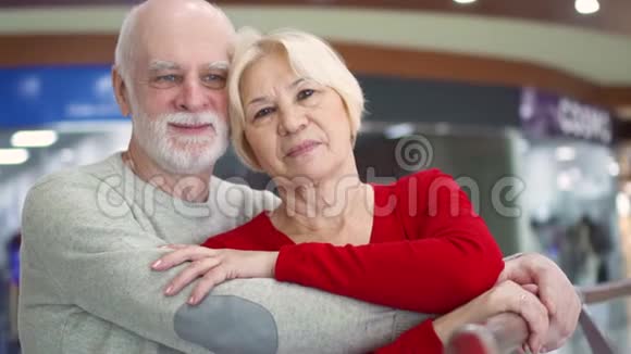 微笑的高级夫妻相爱的肖像幸福的一家人站在商场里拥抱看镜头视频的预览图